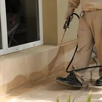 General pest control technician spraying exterior perimeter around a home in Henderson, NV